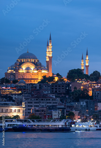 Suleymaniye Mosque with night illumination and minaret of Rustem Pasha Mosque, Istanbul, Turkey