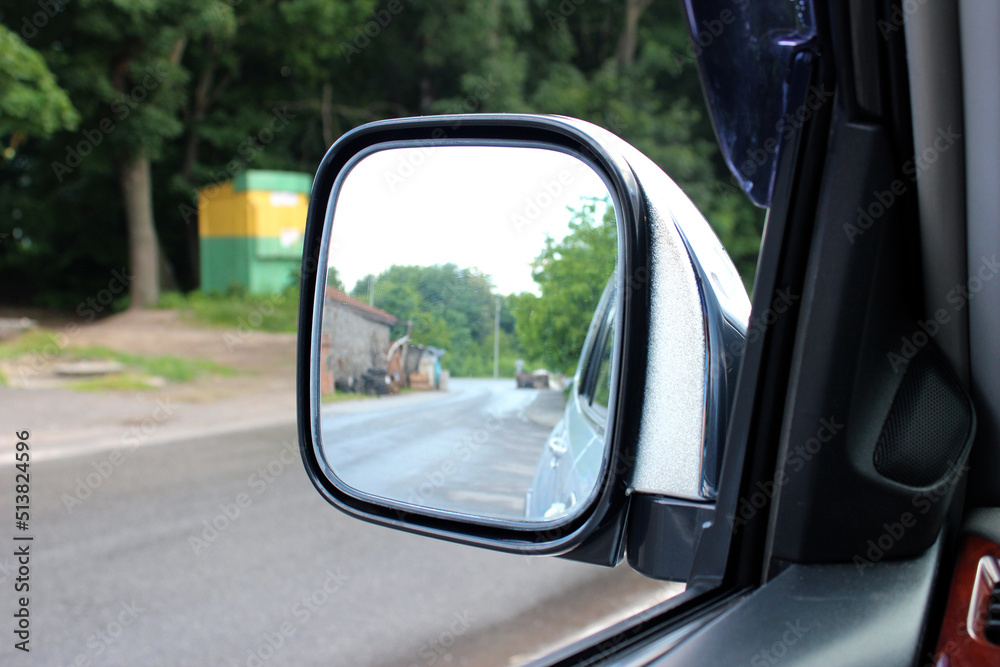 Rear-view mirror. Rearview mirror with reflection in it. Rear view mirror modern SUV on the road. Wing mirror of a classic van.
