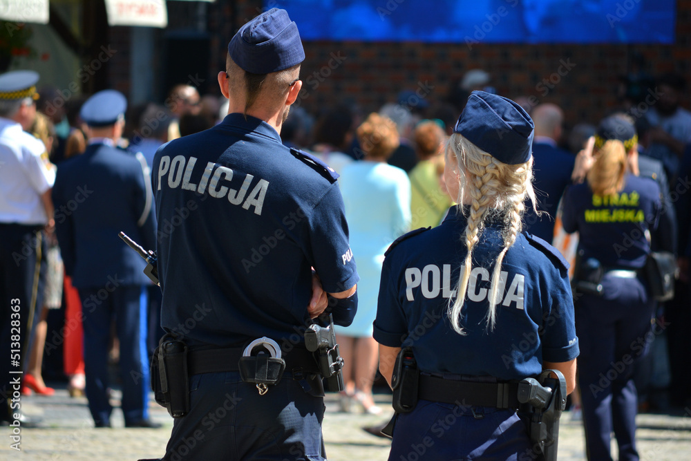 Młoda policjantka blondynka w mundurze na służbie w mieście. - obrazy, fototapety, plakaty 
