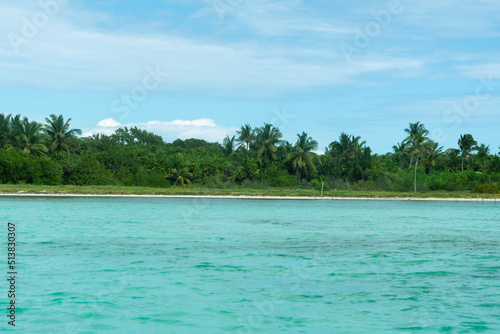 View of a tropical island in the sea. On the horizon is an island covered with dense vegetation. Seascape.