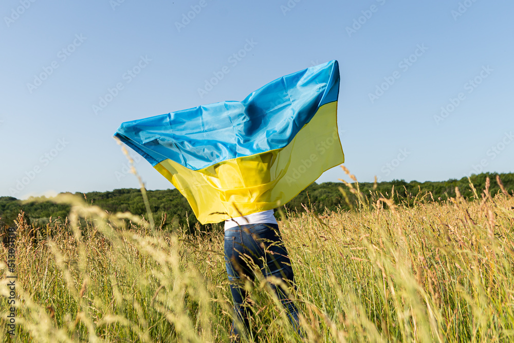 African american woman wrapped in ukrainian yellow blue flag flutters waving in the wind. National symbol of Ukraine. Stand with Ukraine, international support and solidarity