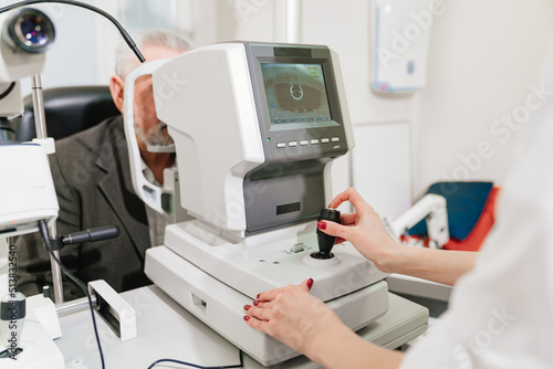 Obraz na plátně doctor examines elderly man's eye on screen of autorefractometer