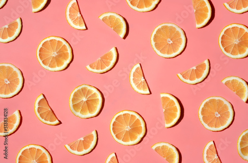 Pattern of many sliced lemons and oranges on a trendy bright pink background. Flat lay, top view. Summer freshness, detox, antioxidants, healthy lifestyle concept