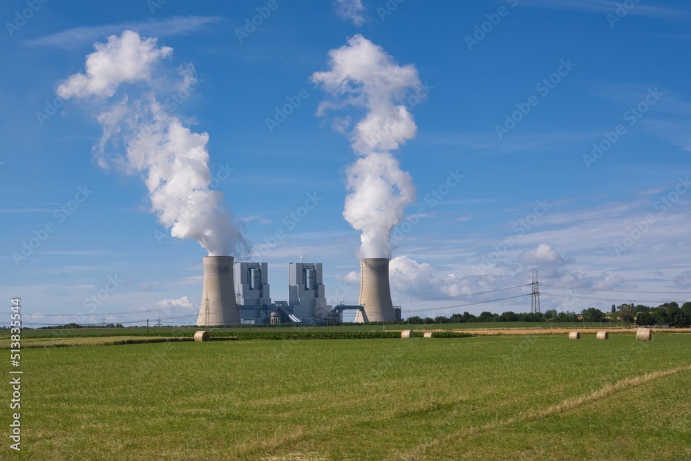 Braunkohlekraftwerk mit Getreidefeld und blauem Himmel 	