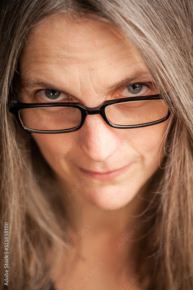 The librarian. A portrait of a mature woman looking disapprovingly over her glasses.
