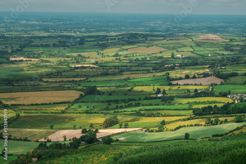 Farmland with green grass field in county Tipperary, Ireland. Stunning Irish landscape scene. Blue cloudy sky. View from a high point. © mark_gusev