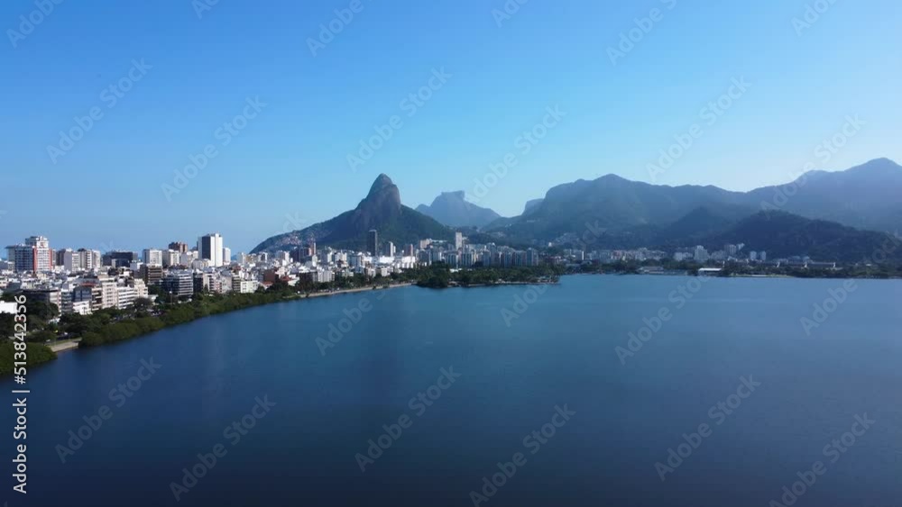 Aerial view of Rodrigo de Freitas Lagoon, south zone of Rio de Janeiro, Brazil. In the background, the beaches of Ipanema and Leblon and Morro Dois Irmãos. Sunny day. Buildings around. Drone take. Aerial view of Rodrigo de Freitas Lagoon, south zone of Rio de Janeiro, Brazil. In the background, the beaches of Ipanema and Leblon and Morro Dois Irmãos. Sunny day. Buildings around. Drone take.