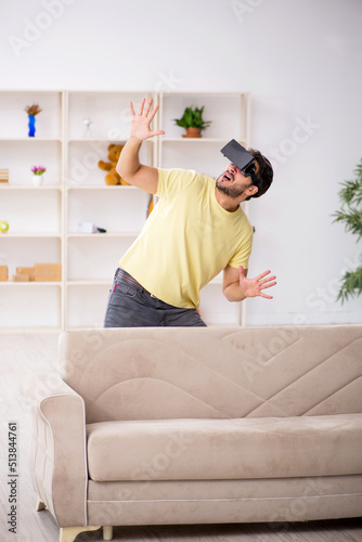 Young man wearing virtual glasses at home © Elnur