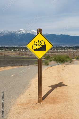 Downhill grade sign along a suburban bicycle trail.
