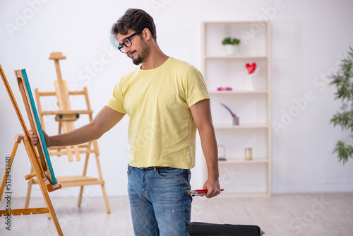 Young man enjoying painting at home