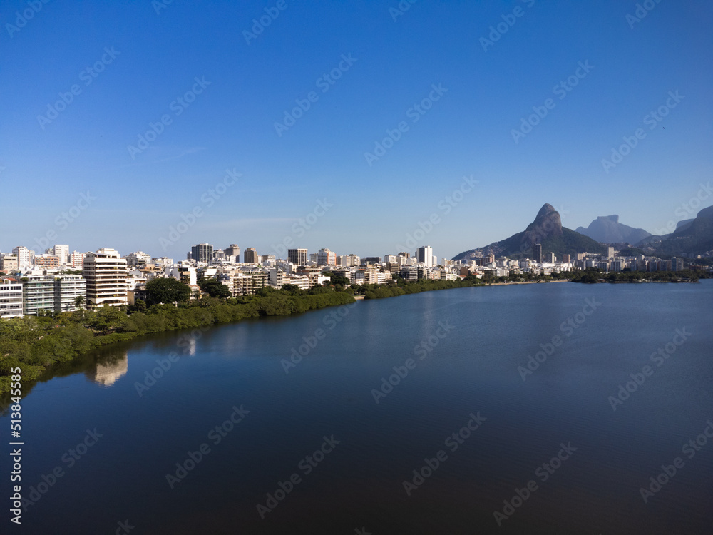 Aerial view of Rodrigo de Freitas Lagoon, south zone of Rio de Janeiro, Brazil. In the background, the beaches of Ipanema and Leblon and Morro Dois Irmãos. Sunny day. Buildings around. Drone photo