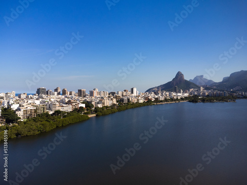 Aerial view of Rodrigo de Freitas Lagoon, south zone of Rio de Janeiro, Brazil. In the background, the beaches of Ipanema and Leblon and Morro Dois Irmãos. Sunny day. Buildings around. Drone photo