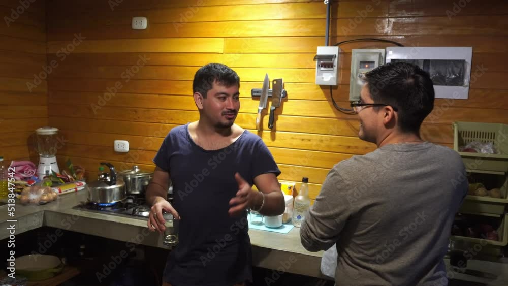 several friends having drinks in the kitchen and looking at the camera talking and smiling several friends having drinks in the kitchen and looking at the camera talking and smiling