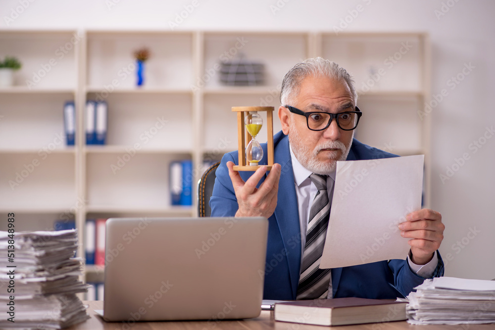 Old male employee in time management concept Old male employee in time management concept