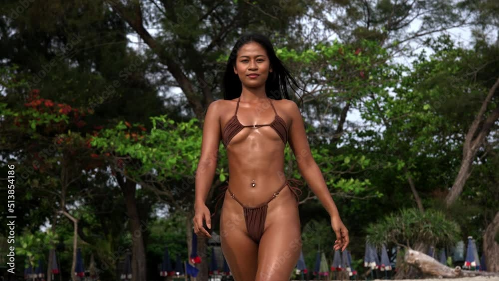 Beautiful Young Woman In Tiny Bikini Walking On Beach