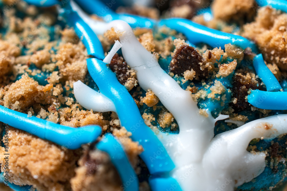 Close-up of blue and white striped frosting with cookie crumbs 