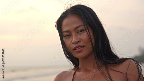Beautiful Young Woman Looking At Camera On Beach At Sunset