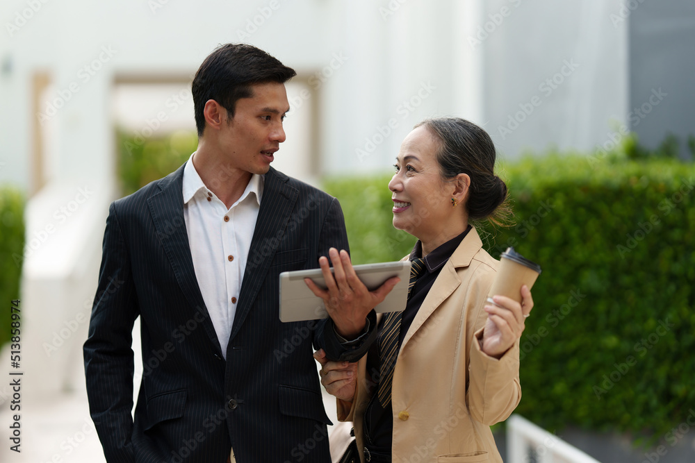 Portrait of Asian Senior Business woman and young business man discussing about Real Estate project. Portrait of Asian Senior Business woman and young business man discussing about Real Estate project.