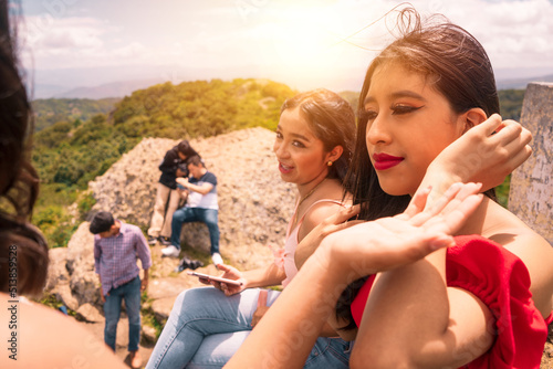 Group of Latino teenagers talking on top of a mountain
