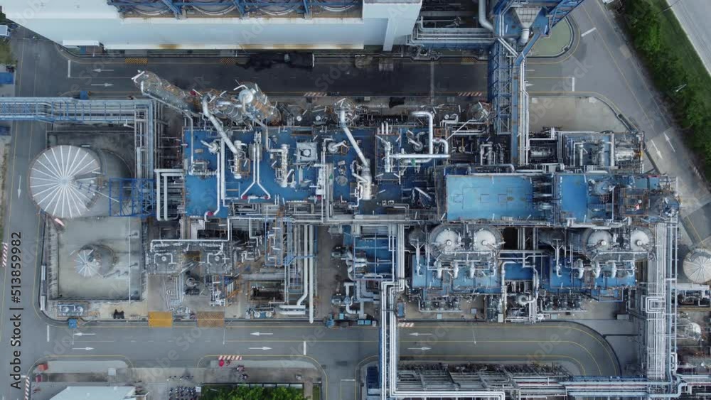 An expansive oil and chemical refinery with metal buildings, pipes, and distillation technology. Aerial view