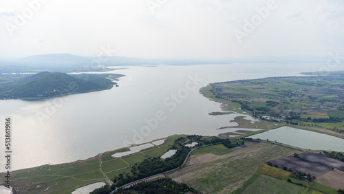 Aerial view from done over camping area inside Pasak Chonlasit dam between duble sugar palm tree with water bay and green area. Most of tourist all this area is 