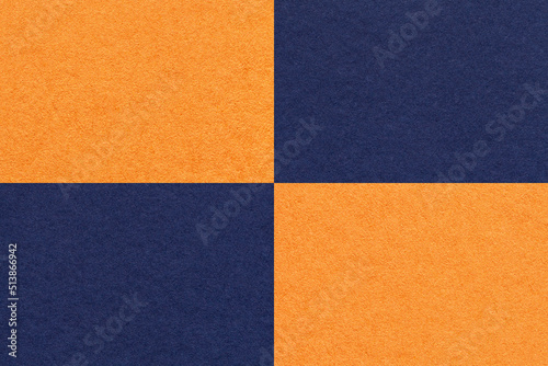 Texture of craft navy blue and orange paper background with cells pattern, macro. Structure of vintage kraft cardboard.