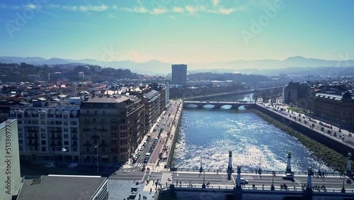 amazing lift up drone shot over Urumea river and the old town of San Sebastián we see the buildings with the Kursaal art gallery the wonders of the sea in background during a lovely sunny day photo