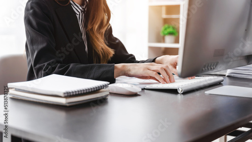 Fotografia Happy businesswoman wearing suit posing sitting in a desktop at office workspace