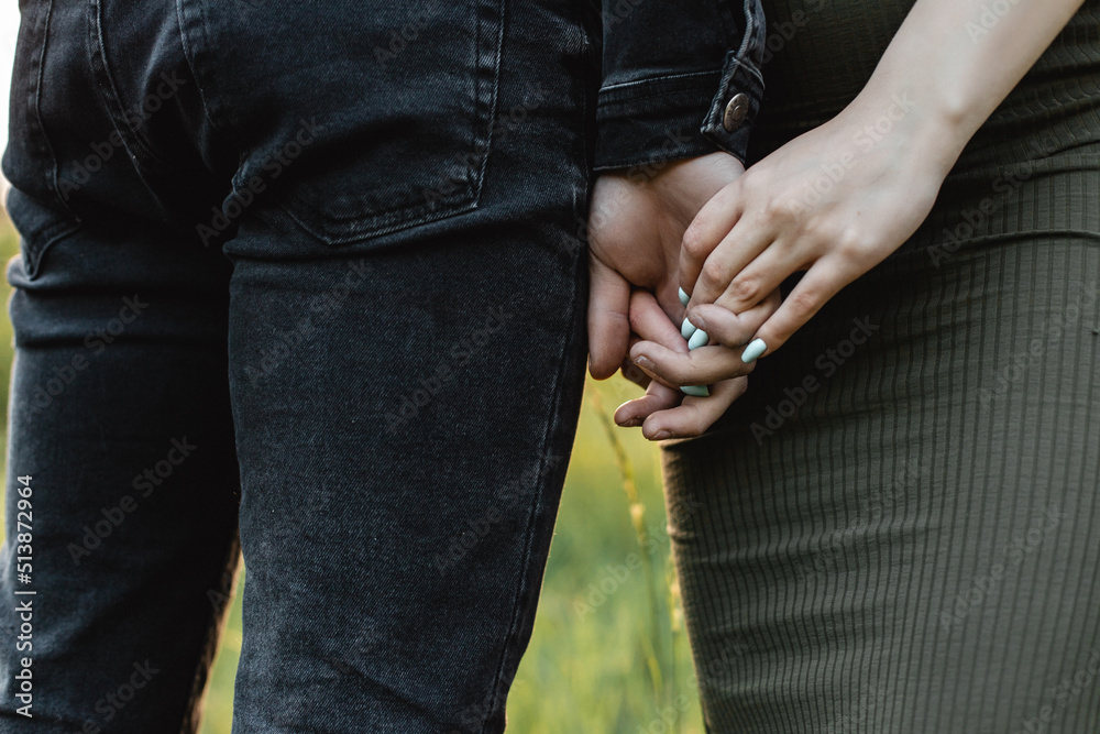 Horizontal close-up photo of a couple holding hands