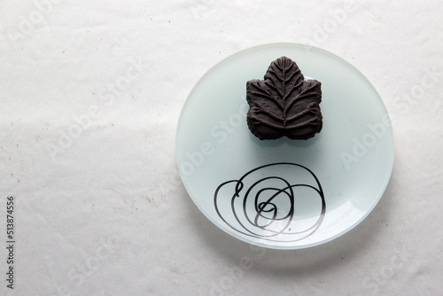 Delicious chocolate cookies filled with vanilla cream made with honey or maple syrup from Canadian trees, the traditional sweet of Canada in white plate on a white bakground