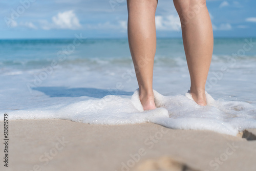 Summer vacation concept barefoot on sand at beach with copyspace.