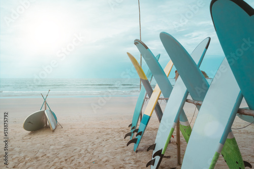 Many surfboards for rent at summer beach with sunlight blue sky.