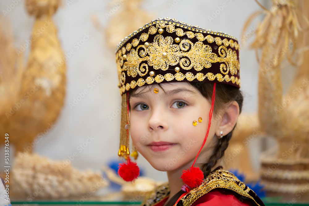 A little girl in the Uzbek national headdress.