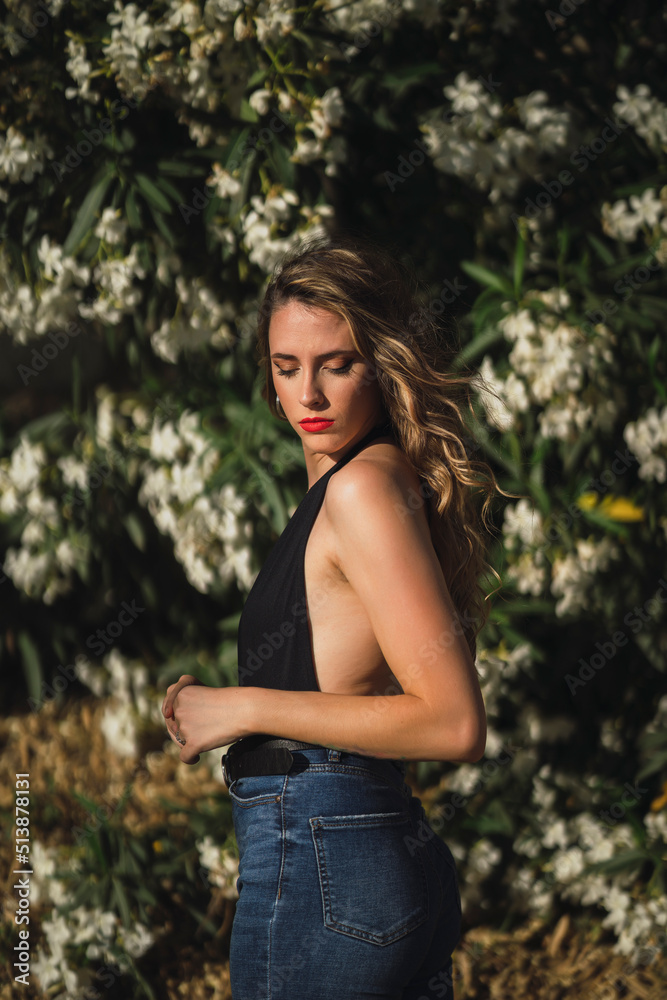 Chica joven delgada posando delante de flores y plantas Chica joven delgada posando delante de flores y plantas
