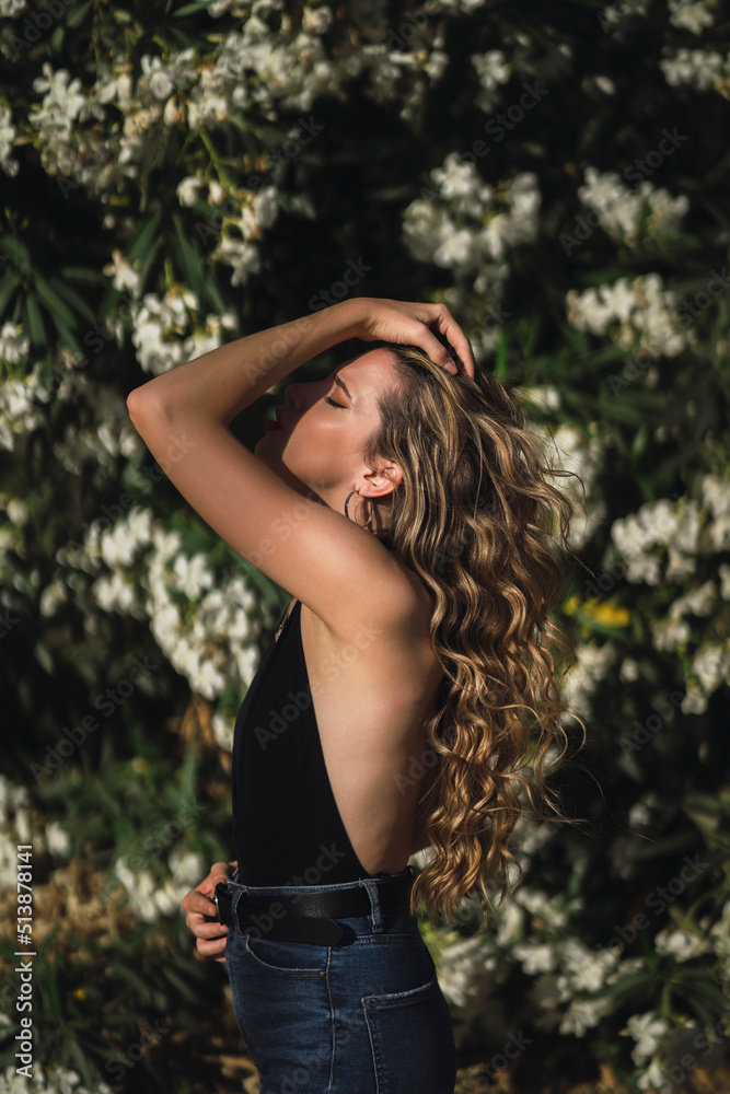 Chica joven delgada posando delante de flores y plantas Chica joven delgada posando delante de flores y plantas