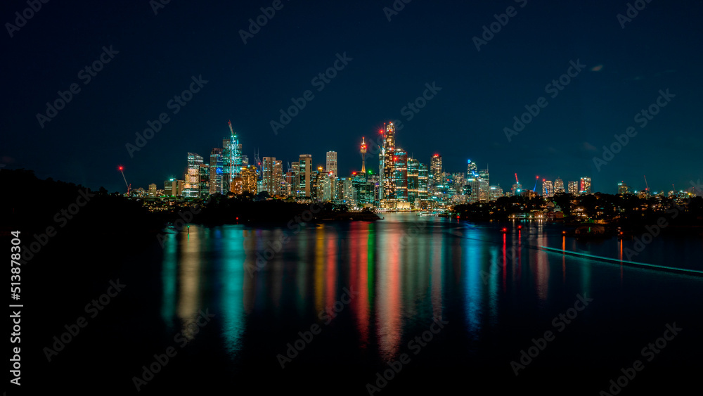 Wide and colorful view of Sydney cityscape at night.