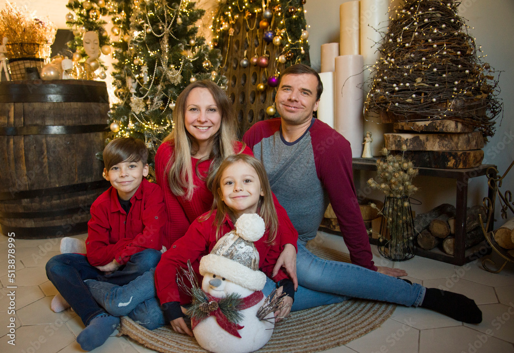 happy family at christmas in red sweaters sitting near christmas tree