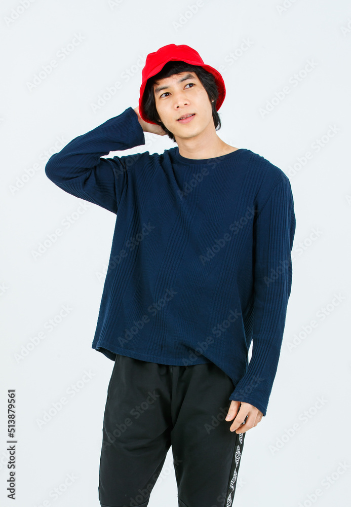 Full body studio shot Asian young handsome slim teenager fashion male model in street style outfit long sleeve shirt standing posing smiling holding hand adjusting red bucket hat on white background Full body studio shot Asian young handsome slim teenager fashion male model in street style outfit long sleeve shirt standing posing smiling holding hand adjusting red bucket hat on white background