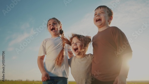 group of kids team hugging a jumping and rejoicing outdoors. happy family teamwork kid dream concept. family children sisters brothers have fun hugging in lifestyle the park in nature