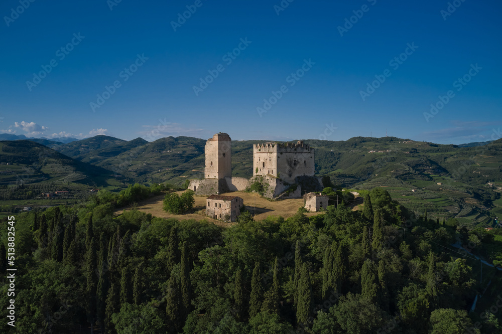 Scaliger Castle of d'Illasi in the province of Verona, built in the 10th century. Medieval castle on a hill aerial view. An ancient castle in Italy surrounded by vineyards is a point of interest.