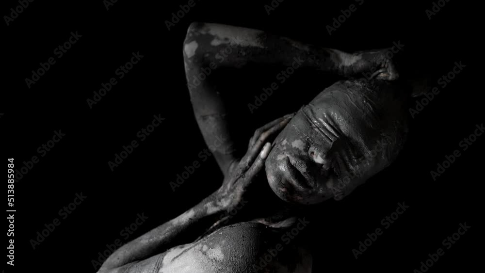 a portrait of a woman with blindfolded eyes and a face smeared with clay. she has one hand on head, the other is stroking neck. close-up. black and white video a portrait of a woman with blindfolded eyes and a face smeared with clay. she has one hand on head, the other is stroking neck. close-up. black and white video
