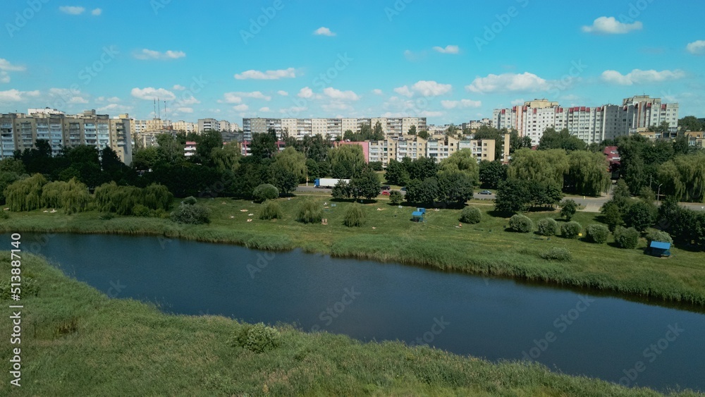 Lake on the outskirts of the city. A pond and multi-storey buildings are visible. Aerial photography.