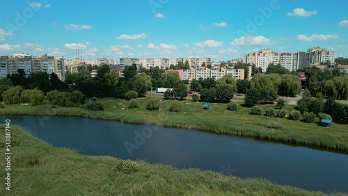 Lake on the outskirts of the city. A pond and multi-storey buildings are visible. Aerial photography.