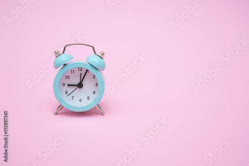 Blue alarm clock on a pink background. Copy space. Close-up. Deadline concept