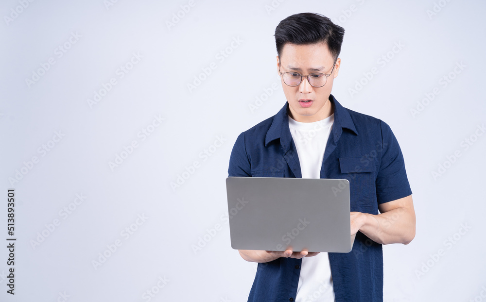 Young Asian man using laptop on white background Young Asian man using laptop on white background