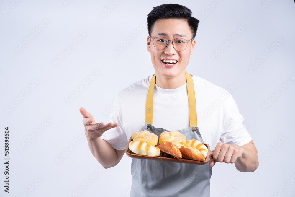 Image of young Asian waiter on background Image of young Asian waiter on background
