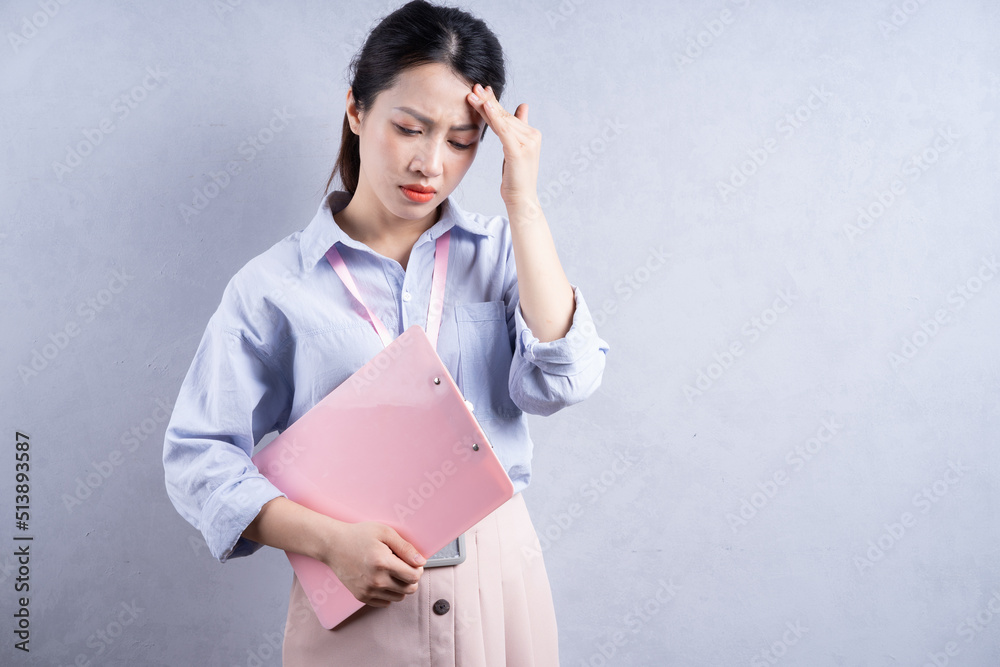 Image of young Asian employee on background Image of young Asian employee on background