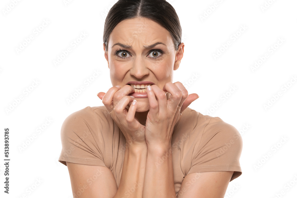Stressed young woman biting her nails on white background Stressed young woman biting her nails on white background