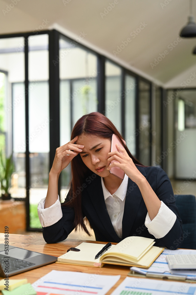 Focused female employee having serious conversation on smartphone, arguing with client, solve business problem Focused female employee having serious conversation on smartphone, arguing with client, solve business problem