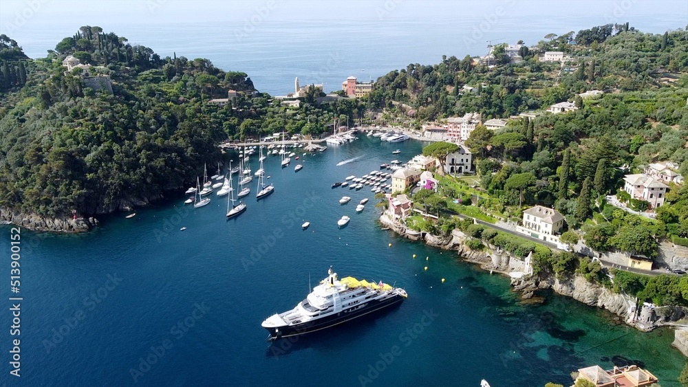 Europe, Italy , Portofino, Liguria - Drone aerial view of Portofino harbor with typical colored houses - boats and amazing sea bay surrounded by nature in Portofino natural park - Tourist attraction 